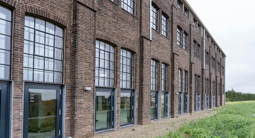 Bedrijfspand met gemetselde gevel en grote stalen ramen